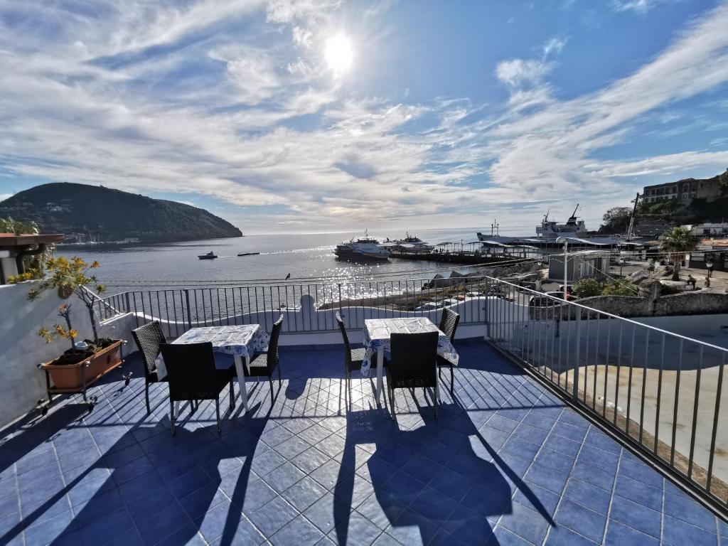 balcone con tavoli, sedie e vista sull'acqua di Lo Nardo Accommodation a Città di Lipari