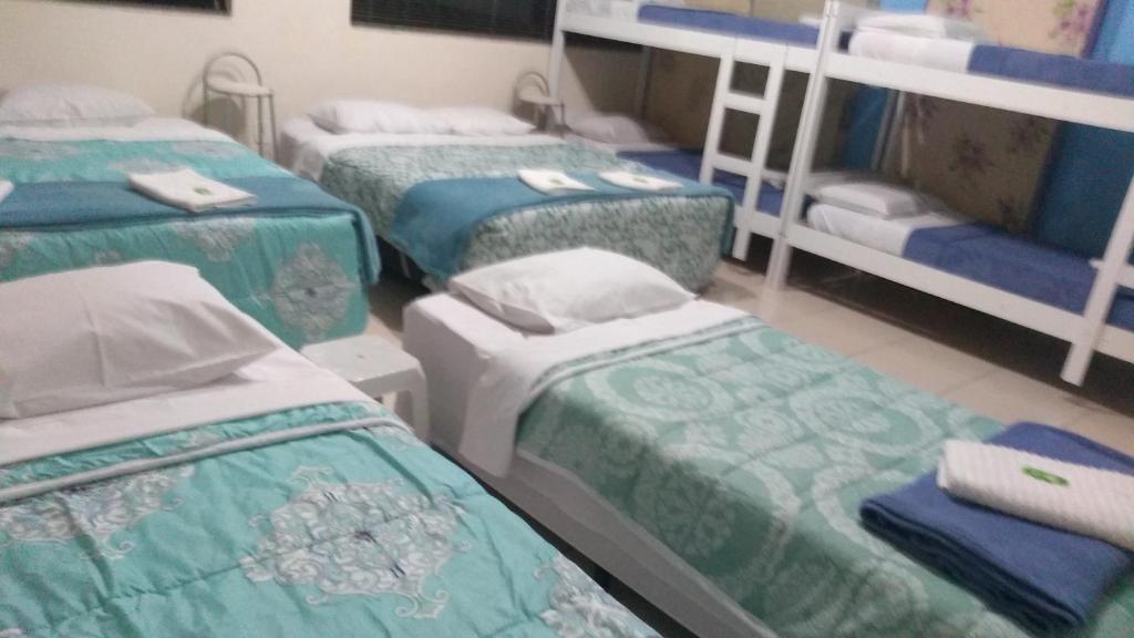 - un groupe de trois lits dans une chambre dans l'établissement Pousada Tilu, à Aparecida