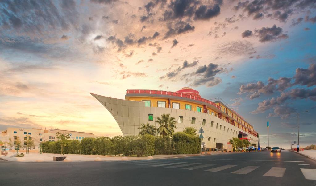 een gebouw op een straat met een bewolkte hemel bij Golden Ship Hotel in Riyad