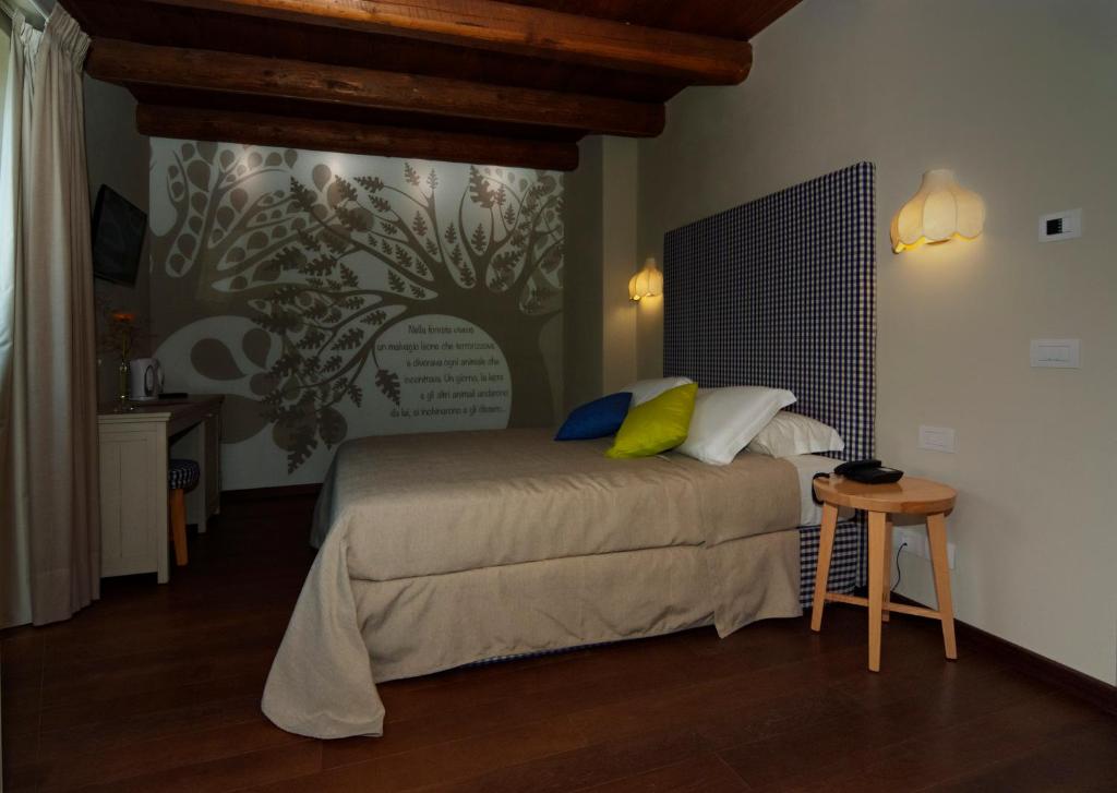 a bedroom with a bed with a tree mural on the wall at Il Falco E La Volpe in Settimo Vittone