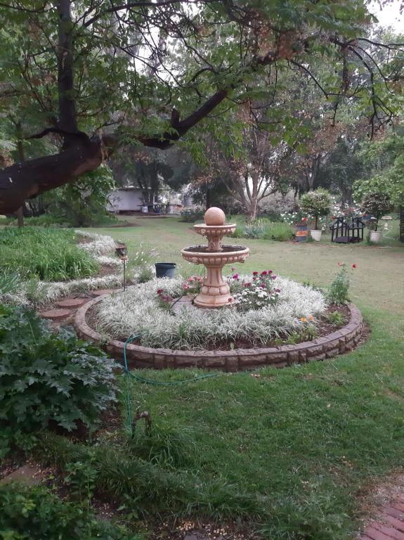 a garden with a fountain in the middle of a park at Soutpan Guesthouse in Soutpan