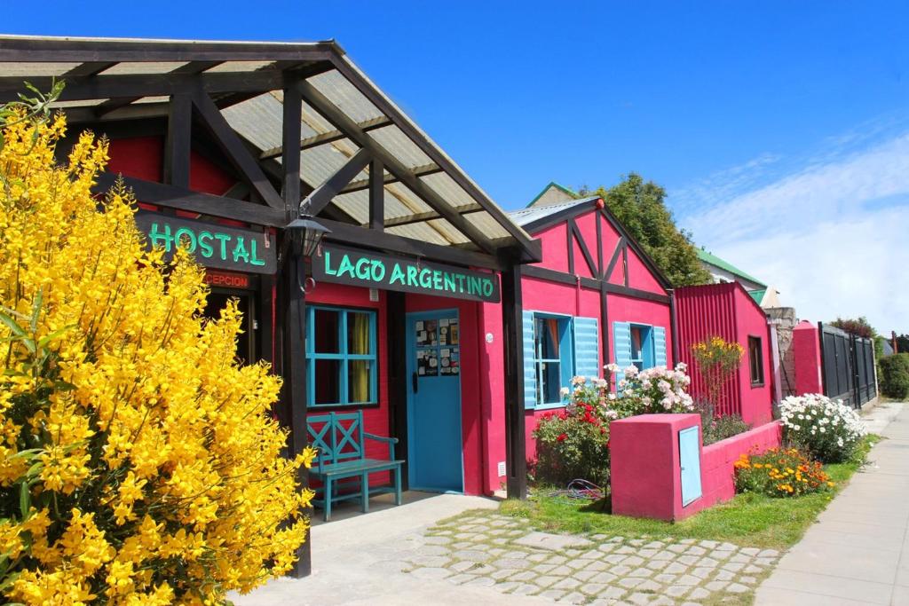 edificio rosso e rosso con un cartello akoya americana di Lago Argentino Hostel a El Calafate
