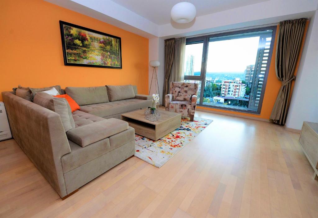 a living room with a couch and a large window at Diva Capitol Luxury in Skopje