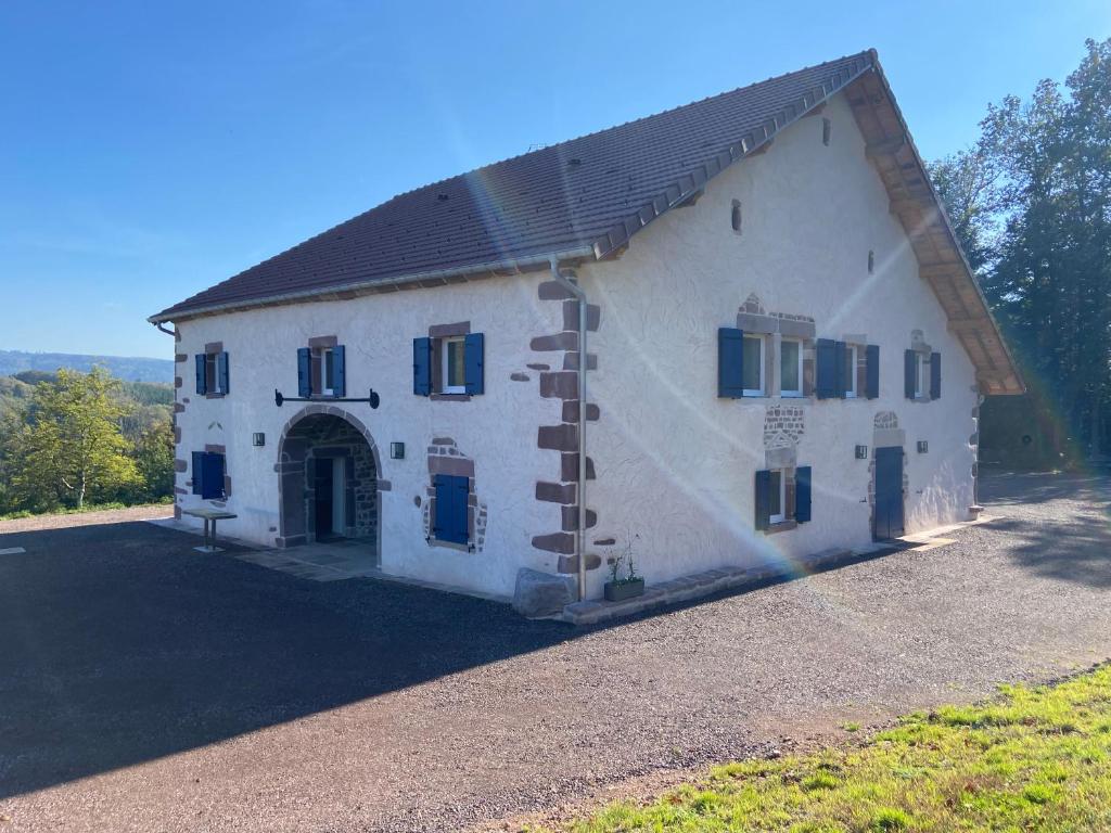 un gran edificio blanco con puerta y ventanas en Gîte des PRARY des Mille étangs, en Ternuay-Melay-et-Saint-Hilaire