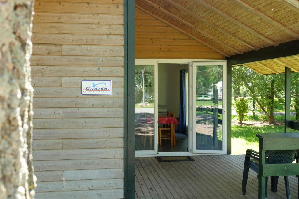 a porch with a sign on the side of a house at Camping Du Port De Plaisance in Péronne