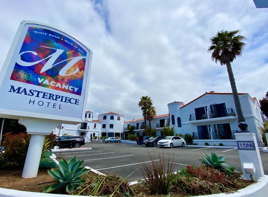 a sign for a mastersurance hotel in a parking lot at Masterpiece Hotel in Morro Bay