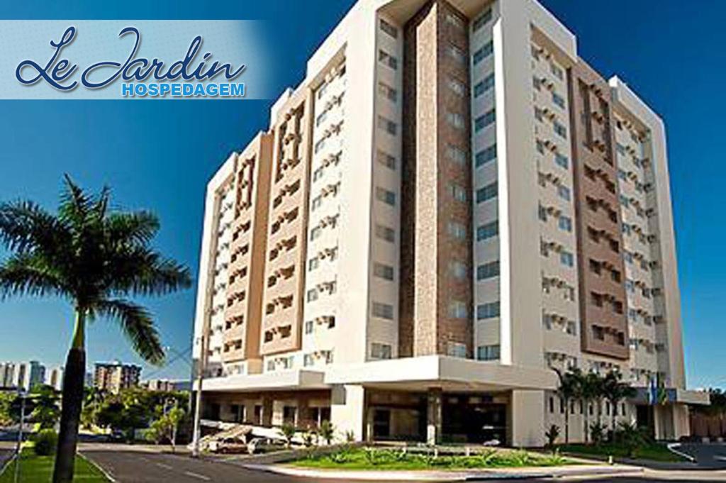 Un gran edificio con una palmera delante. en Le Jardin Hospedagem Caldas Novas, en Caldas Novas