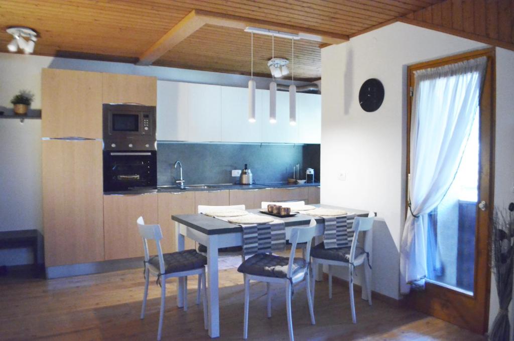 a kitchen with a table and chairs in a room at Appartamenti Ladina in Padola