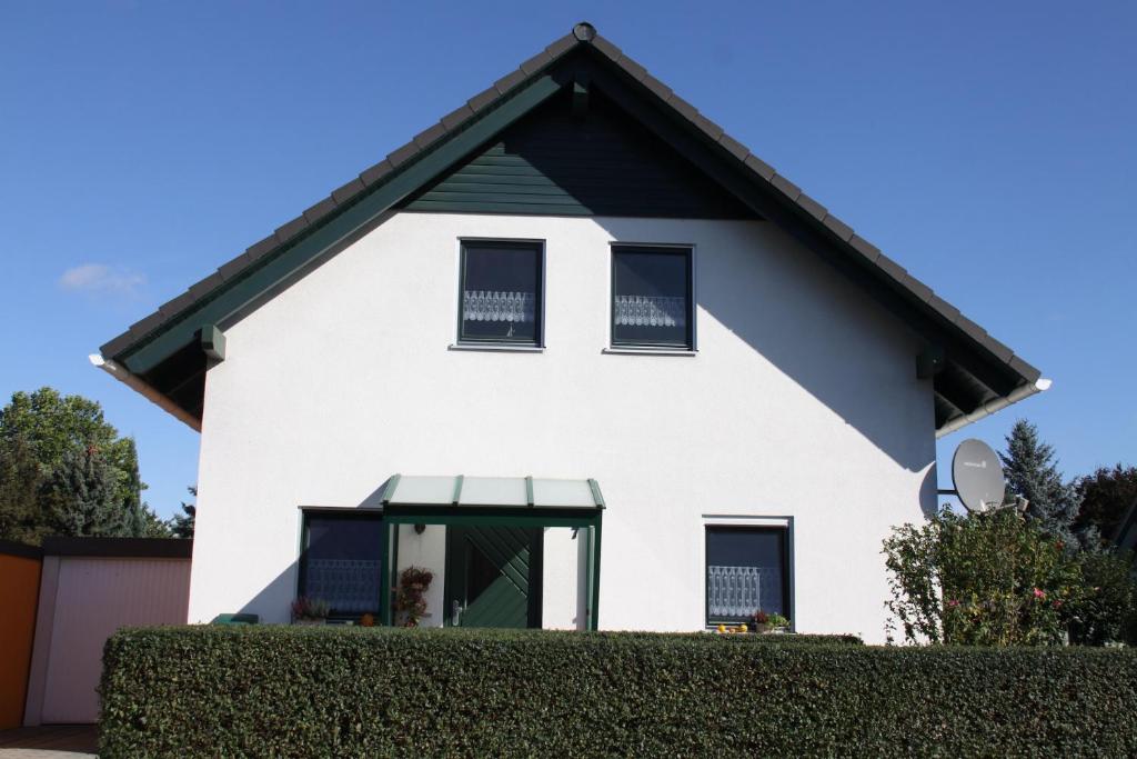 uma casa branca com um telhado preto em Ferienhaus Seenliebe em Senftenberg