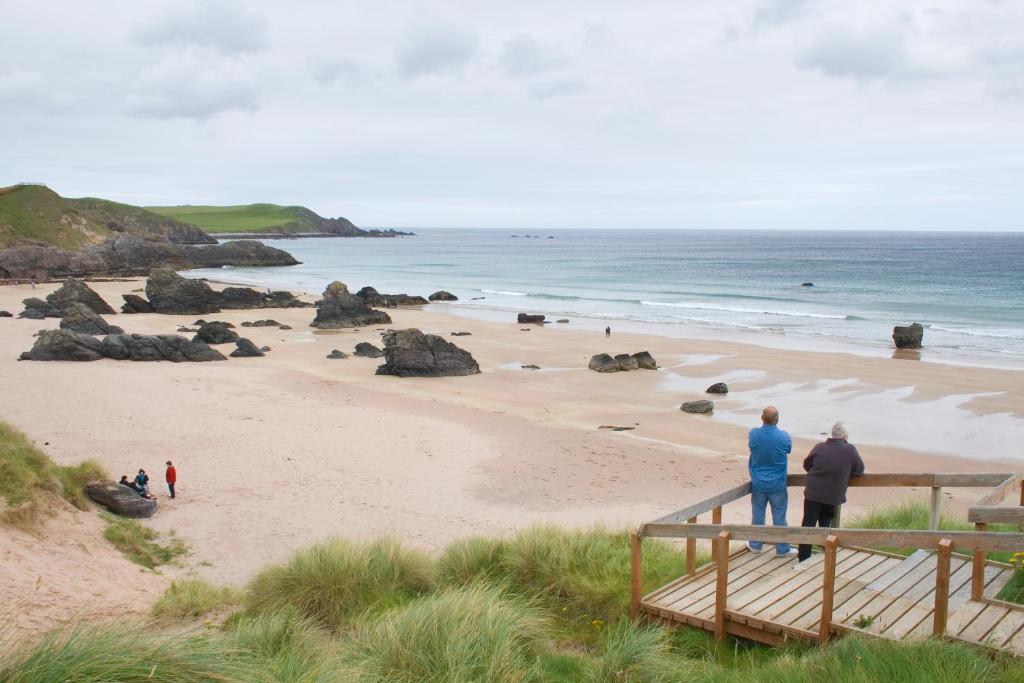 a group of people standing on a beach at Durness Youth Hostel in Durness