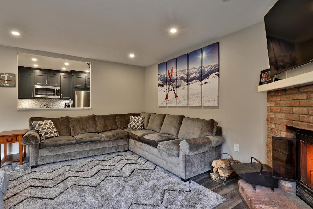 a living room with a couch and a fireplace at Kettle Brook A in Ludlow