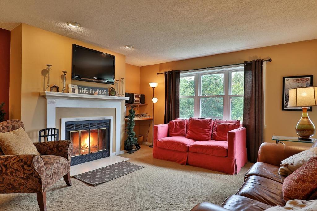 sala de estar con sofá rojo y chimenea en Winter Escape en Ludlow