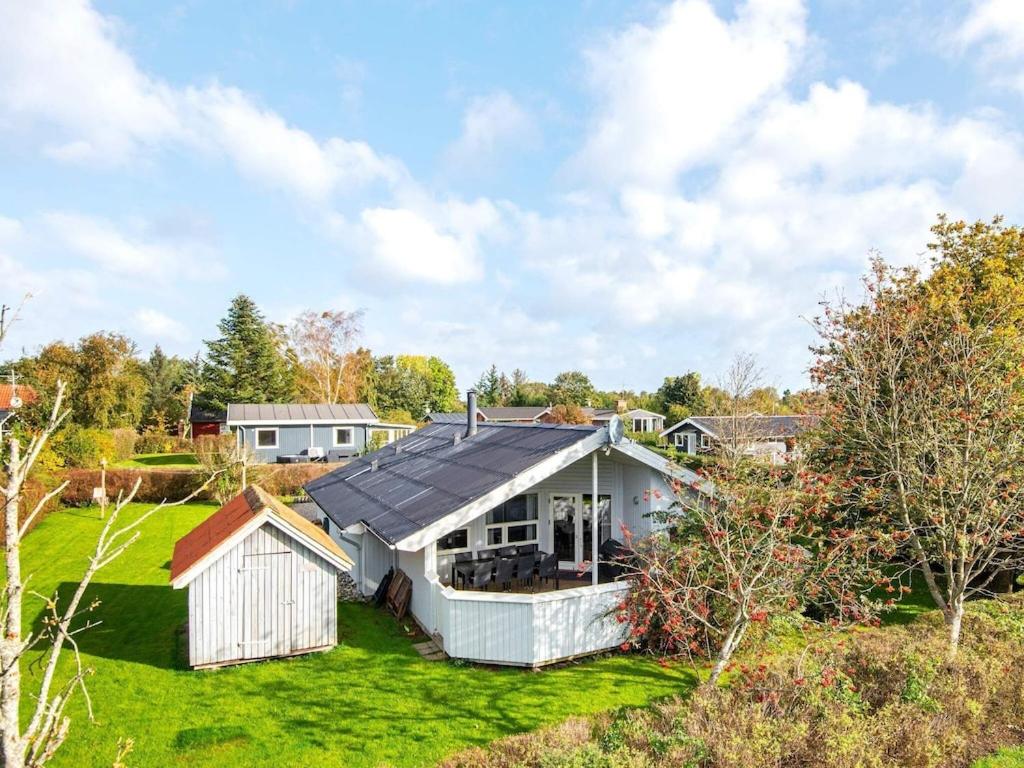 a white house with a solar roof on a yard at 8 person holiday home in Juelsminde in Sønderby