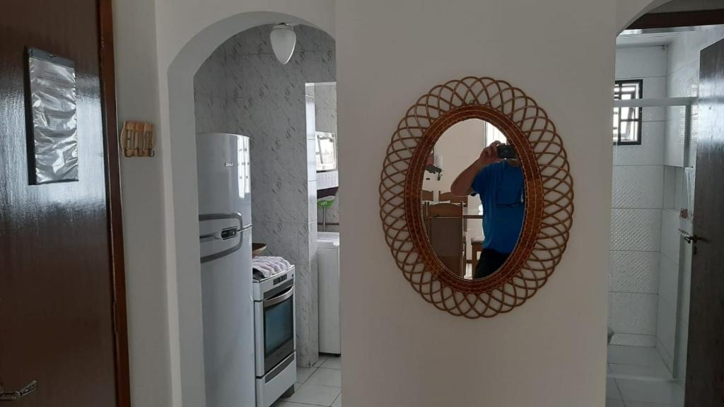 馬蒂尼奧斯的住宿－Excelente apto em Caiobá a 3 quadras da praia!，把镜子照在厨房里的人