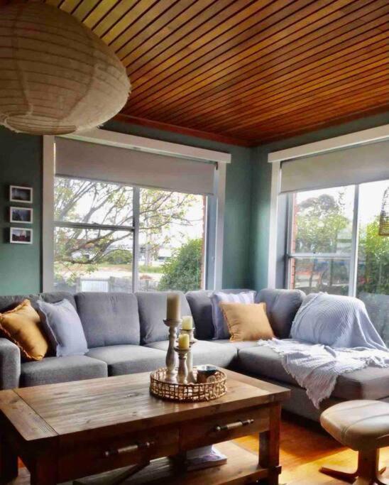 uma sala de estar com um sofá e uma mesa de centro em Lylah’s By The Sea em Wynyard