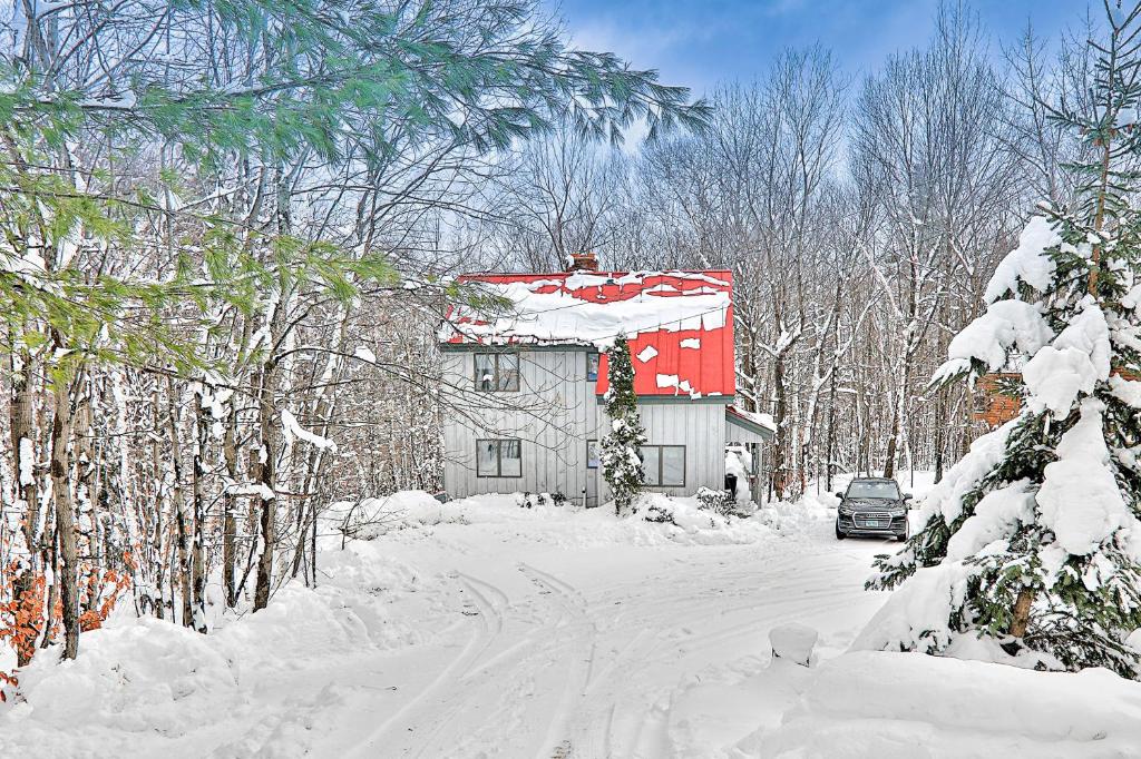 ein Haus im Schnee mit einem Auto daneben geparkt in der Unterkunft 278 Ghia Farm Road in Ludlow