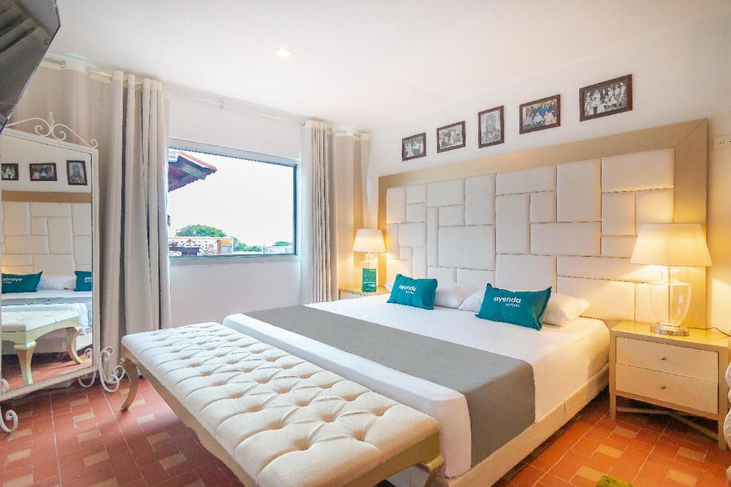 a bedroom with a large bed and a window at Ayenda Cañaguate in Ríohacha