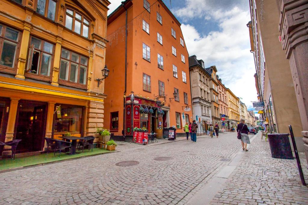 people walking down a street in front of a brick building at ApartDirect Gamla Stan II in Stockholm