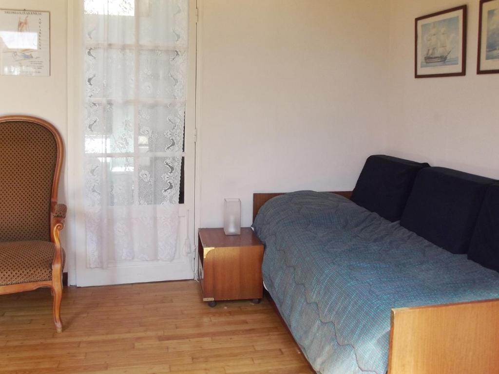 a bedroom with a bed and a chair and a window at Maison d&#39;une chambre a Tredrez Locquemeau a 800 m de la plage avec jardin amenage et wifi in Coat-Tredrez