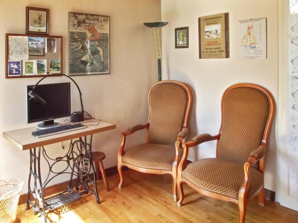 a room with two chairs and a desk with a computer at Maison d&#39;une chambre a Tredrez Locquemeau a 800 m de la plage avec jardin amenage et wifi in Coat-Tredrez