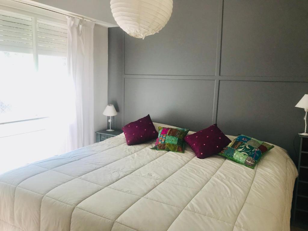 sypialnia z dużym białym łóżkiem z 3 poduszkami w obiekcie Apartamento Segui UNICO LUMINOSO w BuenosAires