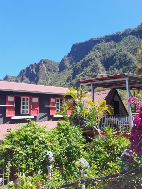 a house with a mountain in the background at Auberge du Cap in Cilaos