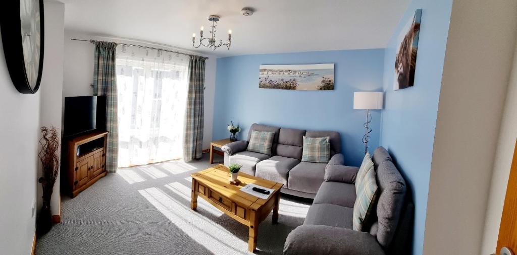 salon z kanapą i telewizorem w obiekcie Hill View 2 bedroom w mieście Inverness