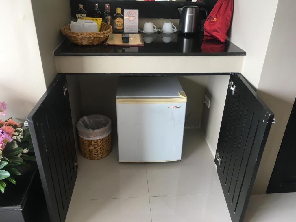 a kitchen counter with a trash can under a table at The Front Hotel and Apartments in Patong Beach