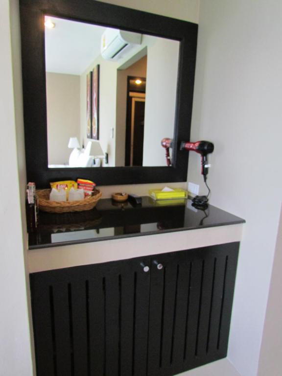 a bathroom vanity with a mirror and a sink at The Front Hotel and Apartments in Patong Beach