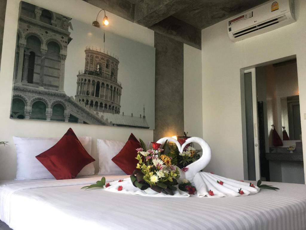 a bed with a swan made out of flowers on it at The Front Hotel and Apartments in Patong Beach
