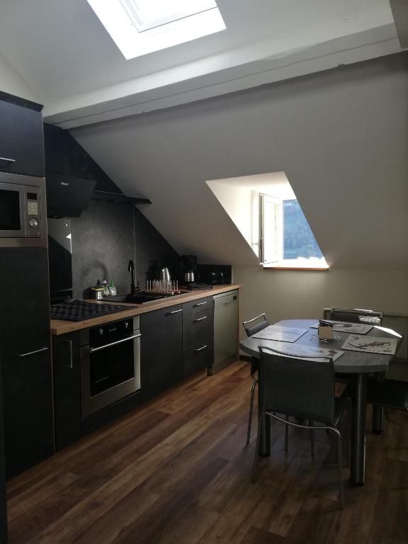 Il comprend une cuisine avec une table à manger et une lucarne. dans l'établissement Appartement au cœur de LUZ, à Luz-Saint-Sauveur