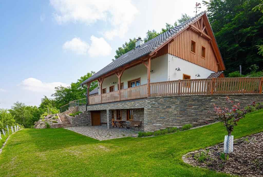 a large house with a balcony on top of a yard at Chalupa Paseky in Vápenice