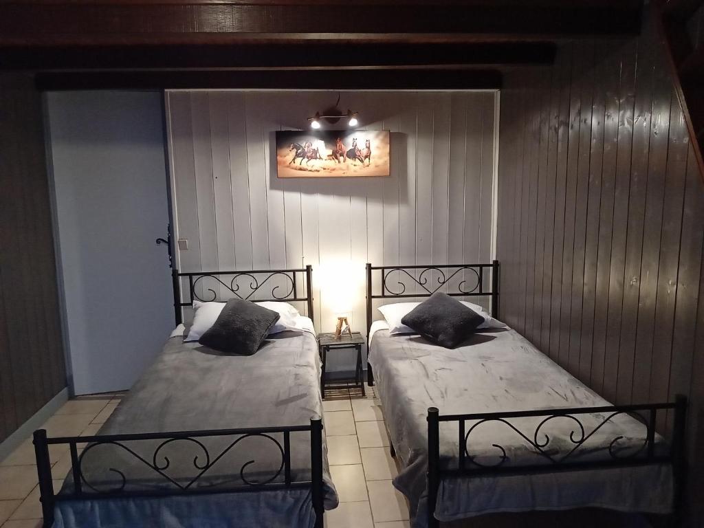 two beds sitting next to each other in a bedroom at Le H de SERNHAC in Sernhac