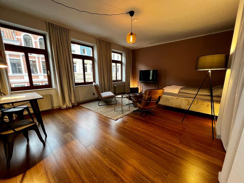 a bedroom with a bed and a desk and chairs at elegant and relaxing nordstadt studio in Hannover