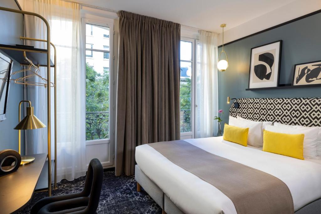 
a bedroom with a large bed and a large window at Hôtel Palais De Chaillot in Paris
