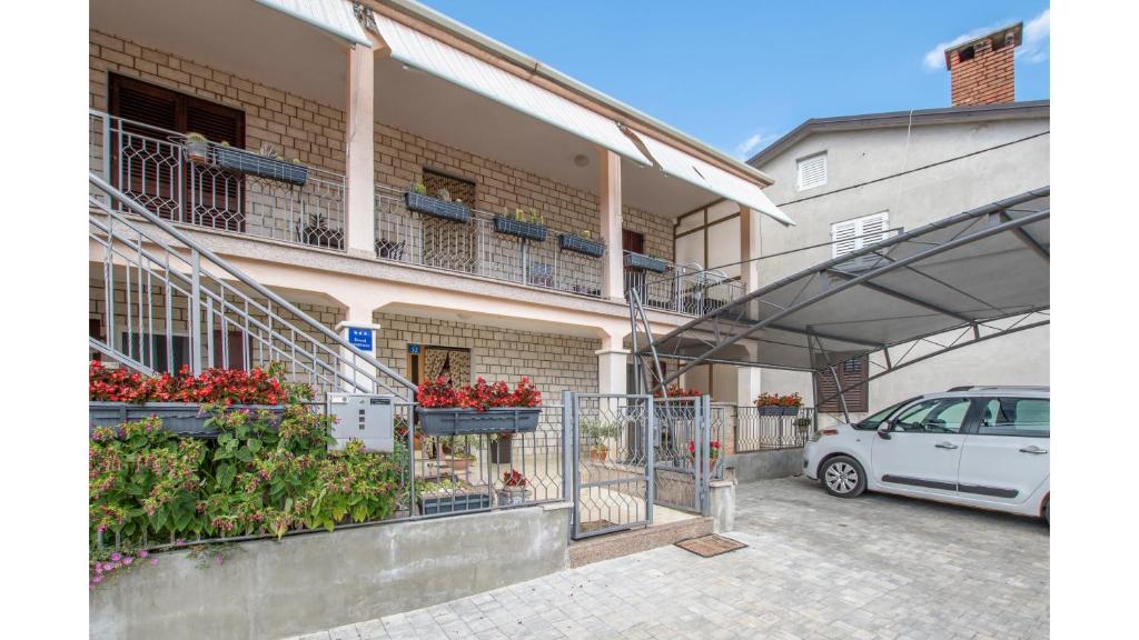 um carro branco estacionado em frente a um edifício em Apartment Erin em Umag