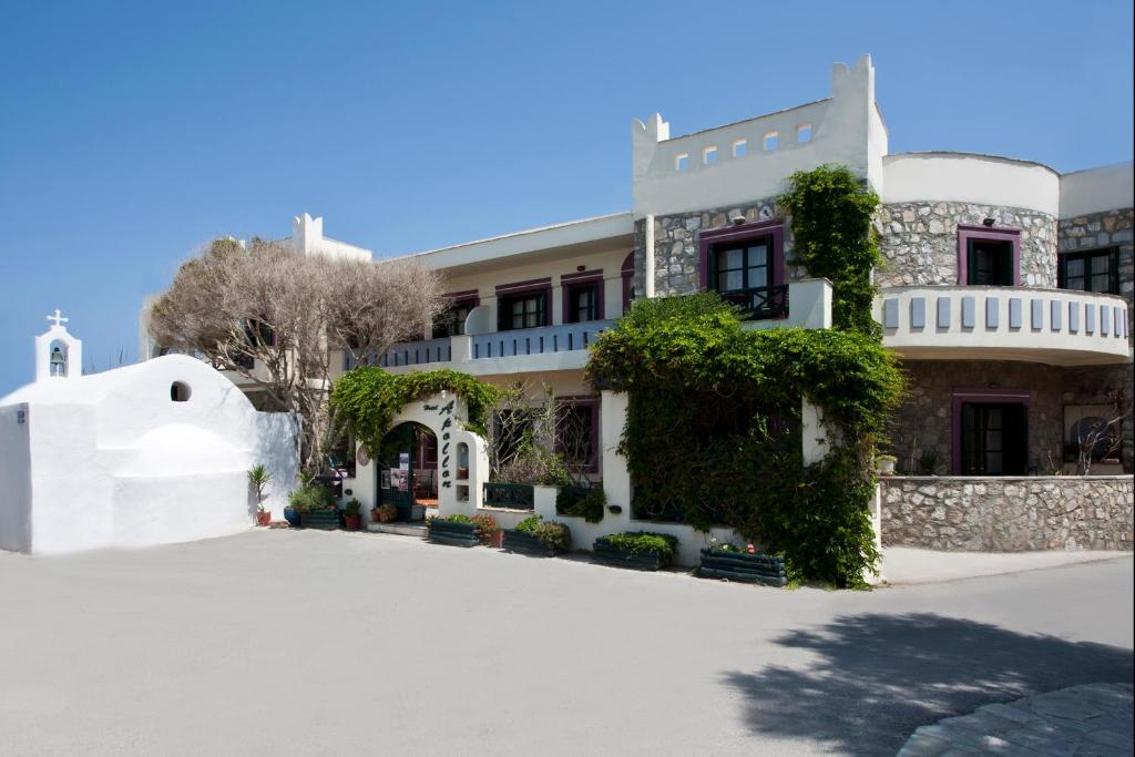 un gran edificio blanco con hiedra. en Apollon Hotel, en Naxos Chora