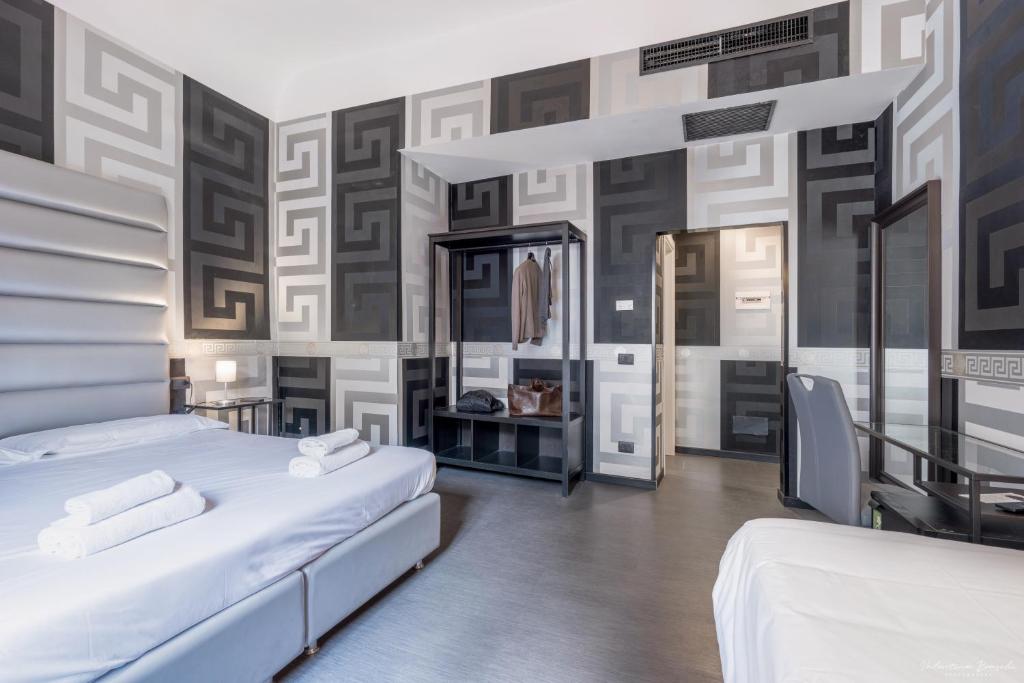 Hotel Deco في فلورنسا: سريرين في غرفة بجدران سوداء وبيضاء