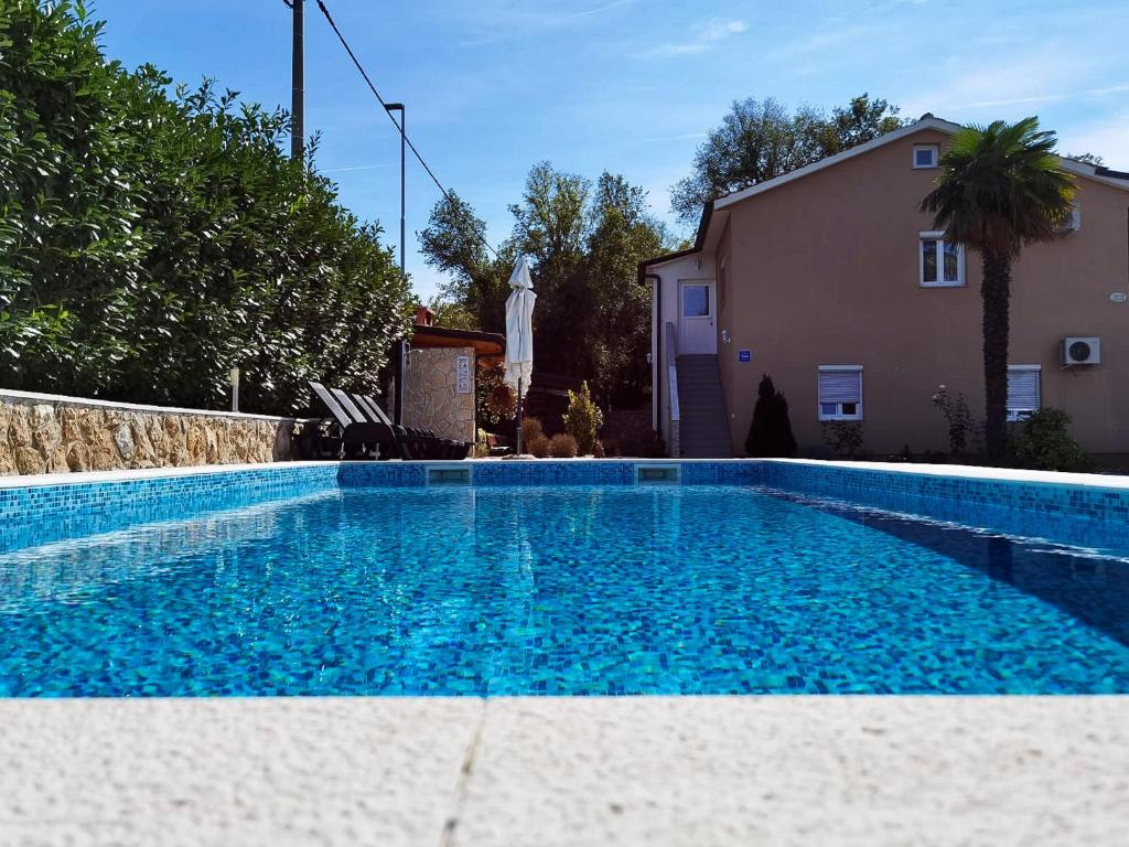 a swimming pool in front of a house at Apartments Beciri in Sveti Vid-Miholjice