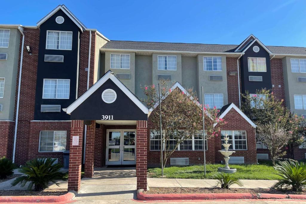 an apartment building with a sign that reads at Super 8 by Wyndham San Antonio Downtown NE in San Antonio