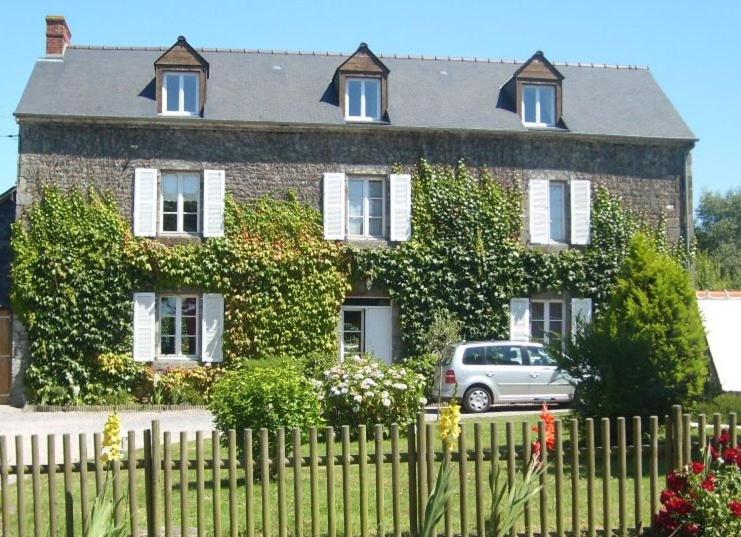 une maison avec une voiture garée devant elle dans l'établissement Domaine de la Basse Orme, à Les Iffs