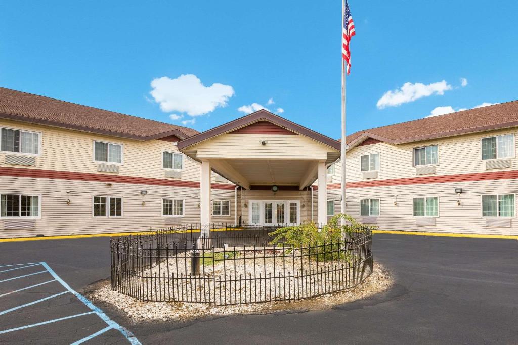 un bâtiment arborant un drapeau américain dans un parking dans l'établissement Econo Lodge, à Lake Mills