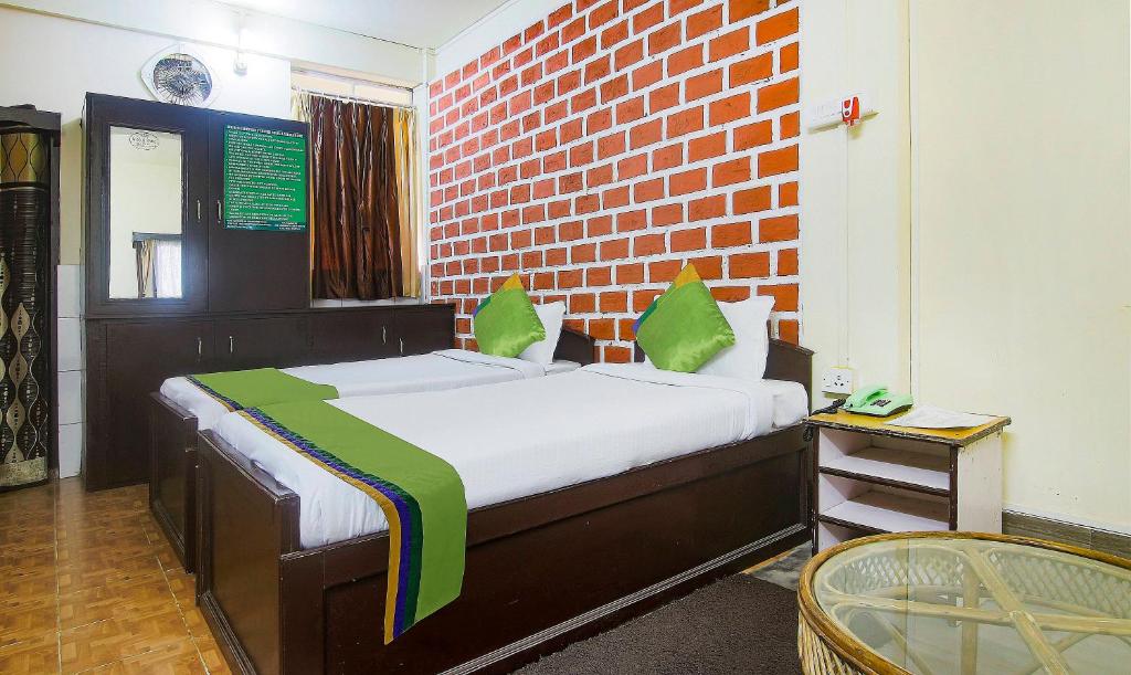 a bedroom with a bed with a brick wall at Treebo Trend JKR Residency in Shillong