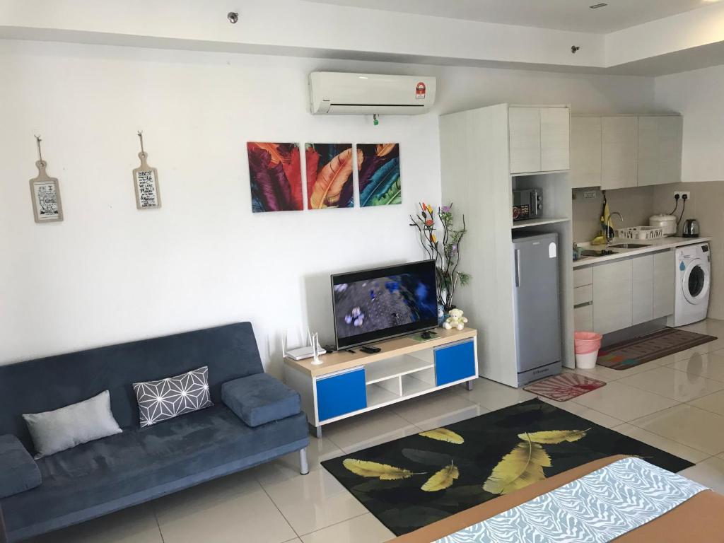 uma sala de estar com um sofá azul e uma cozinha em Studio I-Soho D'Gunduls Homestay by DGH I-CITY em Shah Alam