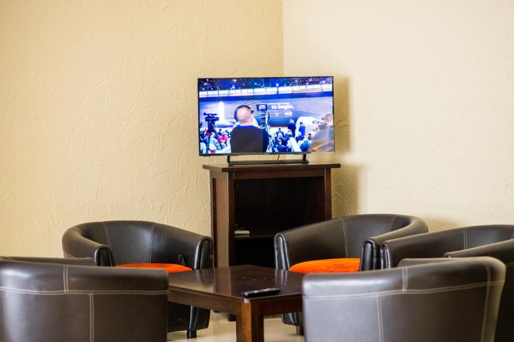 Habitación con mesa, sillas y TV. en Hotel Vaslui, en Vaslui