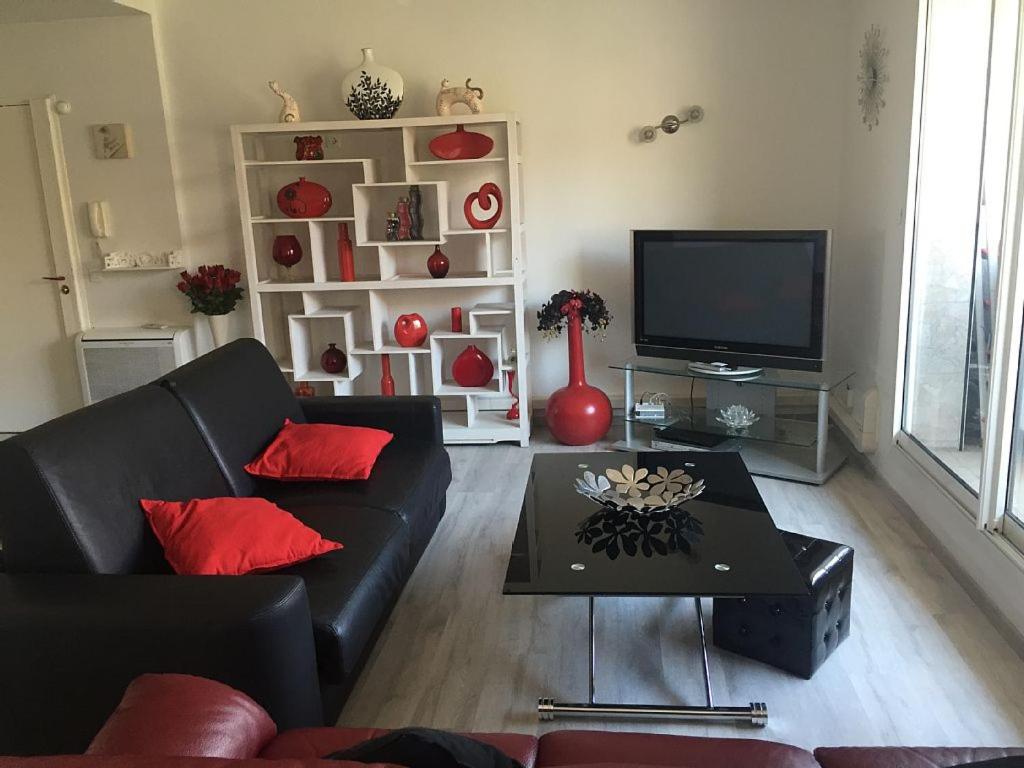 sala de estar con sofá negro y TV en MAGNIFIQUE T3 85m2 VIEUX PORT/CORNICHE en Marsella