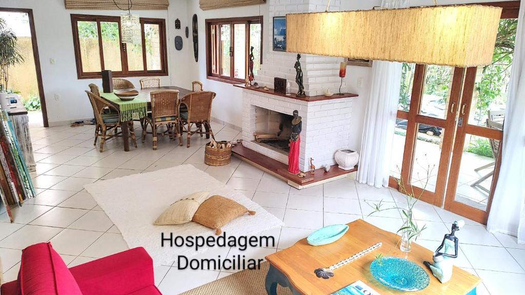 sala de estar con mesa y chimenea en Maison de La Mer 300m da praia, en Florianópolis