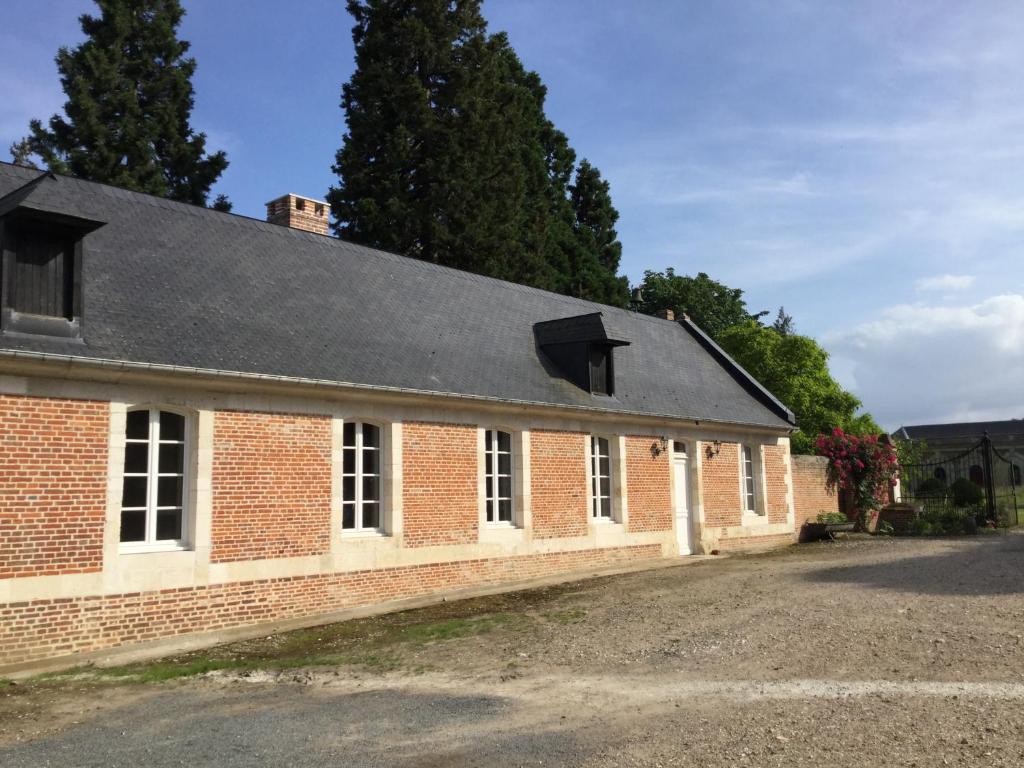 un edificio de ladrillo rojo con techo negro en Pavillon de la Garde en Courcelles-sous-Moyencourt