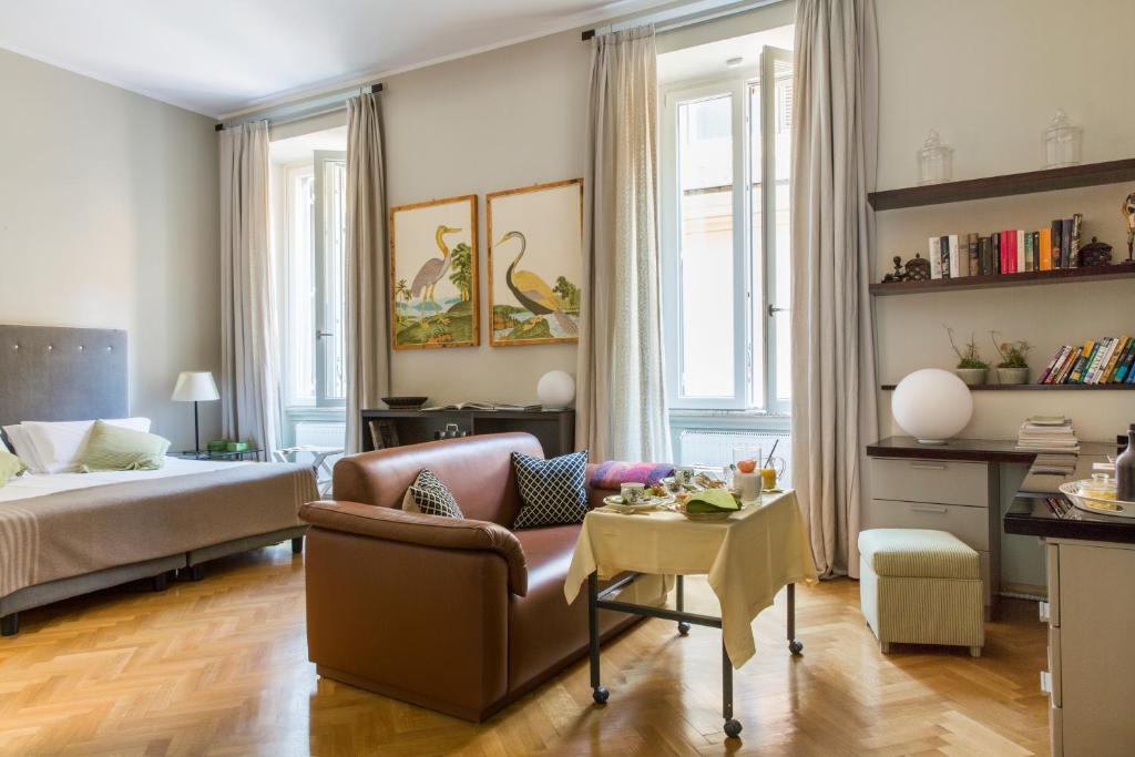 ein Wohnzimmer mit einem Bett, einem Sofa und einem Tisch in der Unterkunft NavonaMyHome in Rom