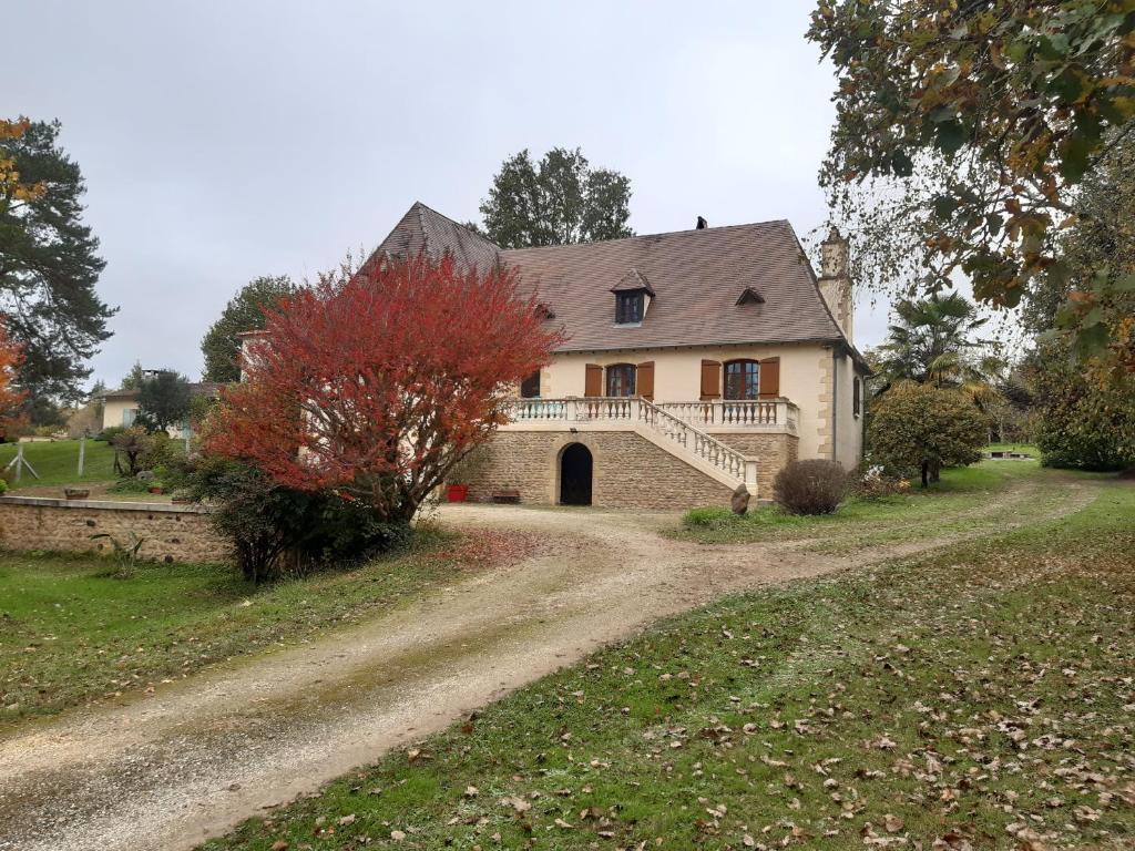 a house with a dirt road in front of it at Location de vacance au coeur du Périgord Noir in Le Bugue